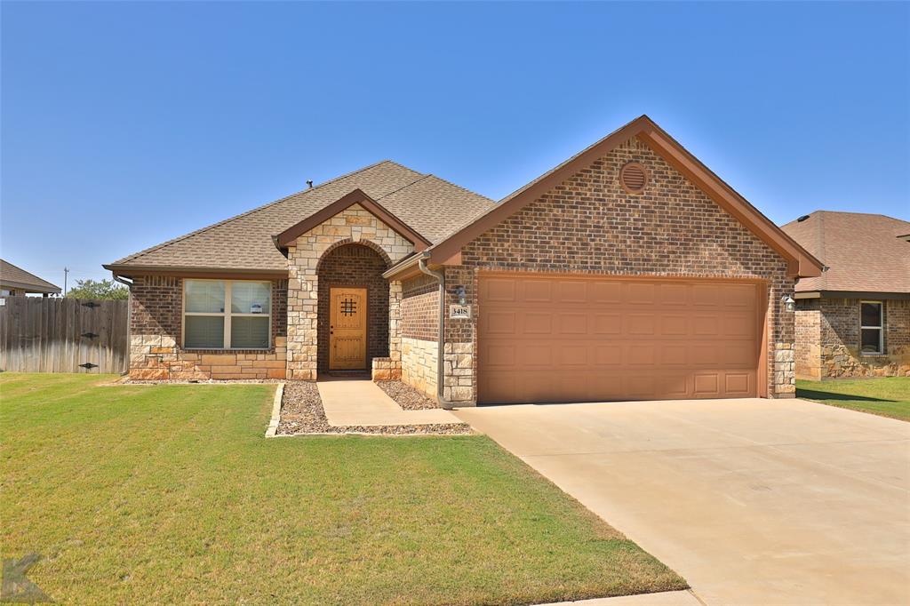 a front view of a house with a garden and yard