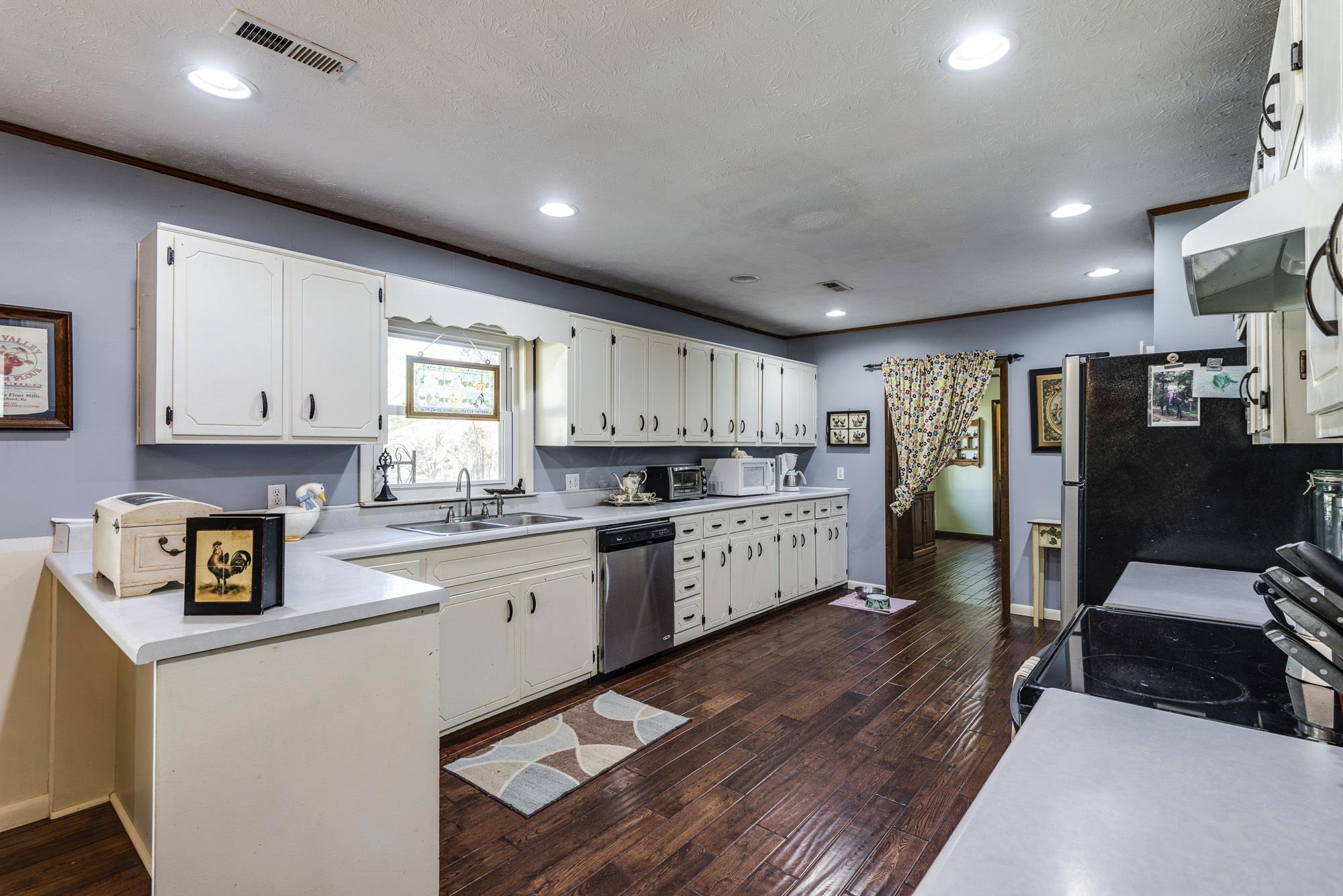 7451 Martin Road Baxter, TN 38544 - Photo 12 of 29 a kitchen with stainless steel appliances granite countertop a refrigerator a sink dishwasher a stove and white countertops with wooden floor