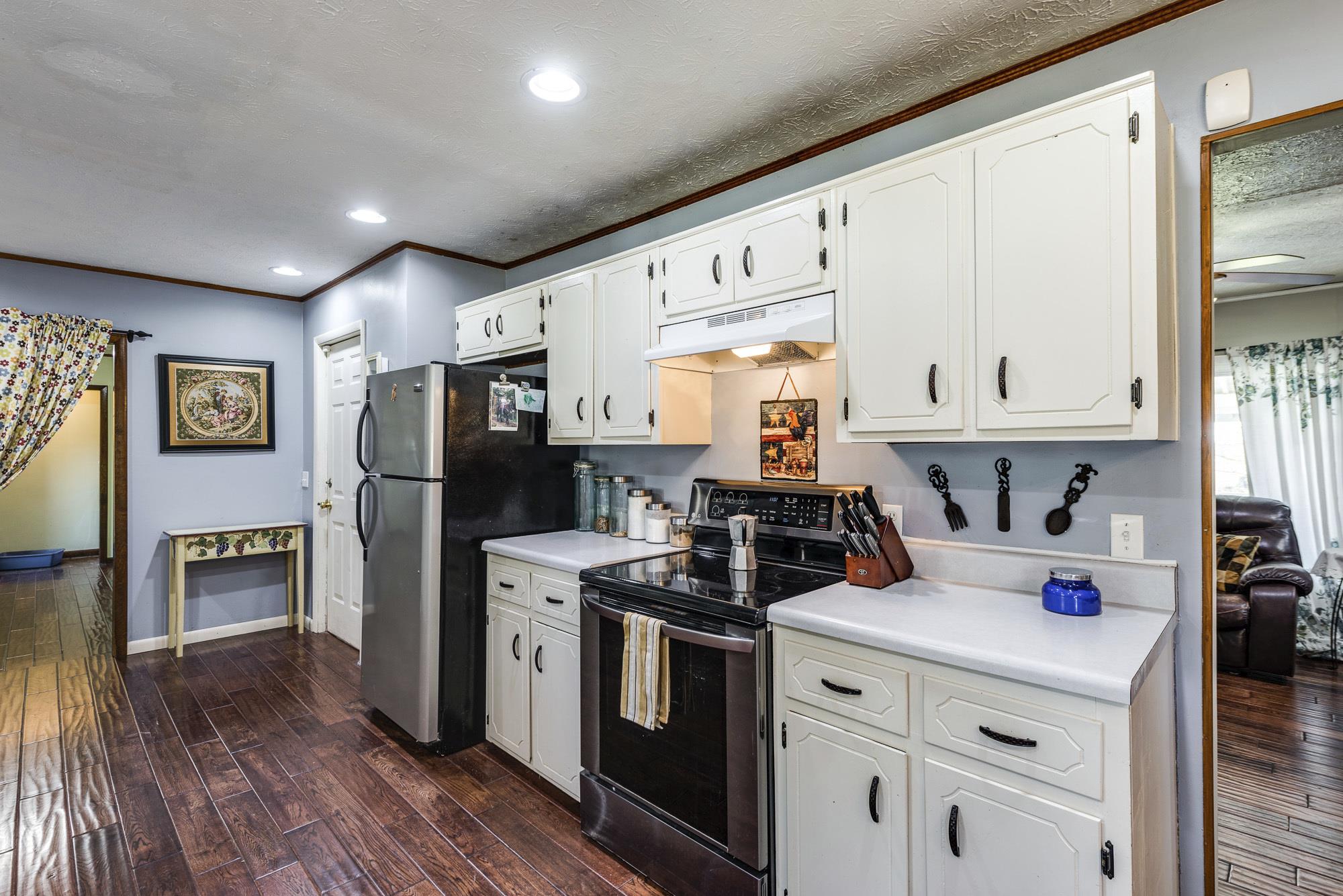 7451 Martin Road Baxter, TN 38544 - Photo 13 of 29 a kitchen with stainless steel appliances a stove a refrigerator a sink dishwasher and wooden cabinets with wooden floor