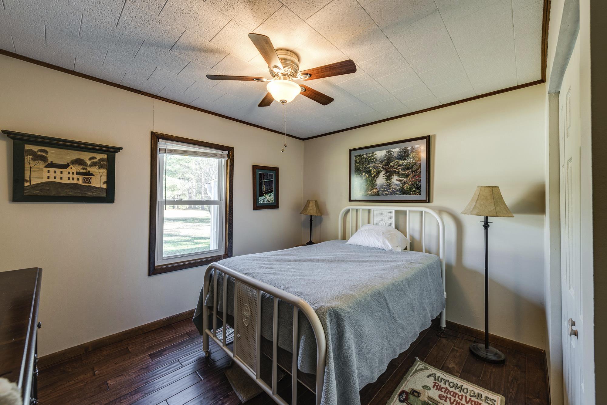 7451 Martin Road Baxter, TN 38544 - Photo 20 of 29 a bedroom with a bed a window and a chandelier