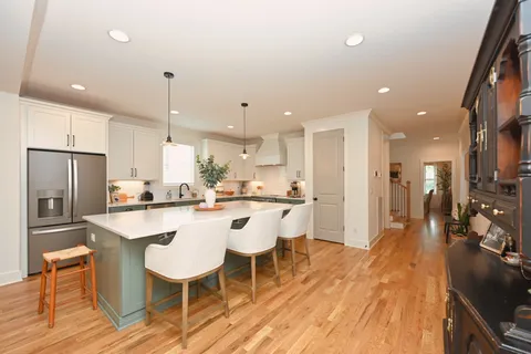 a kitchen with a sink a counter top space a large window and stainless steel appliances