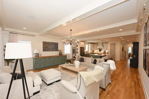 a living room with furniture dining area and a chandelier