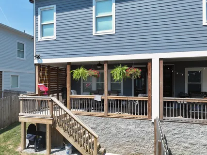 a view of a house with a large window and wooden fence