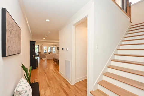 a view of a hallway with wooden floor and stairs