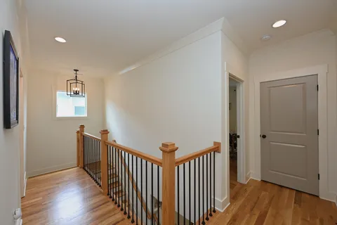 a spacious bedroom with a bed and wooden floor
