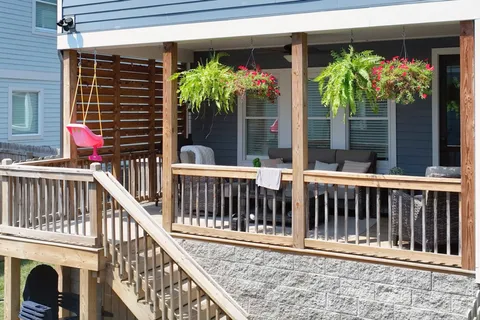 a view of small house with floor to ceiling windows and yard