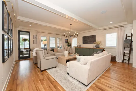 a large white kitchen with a dining table chairs and white cabinets