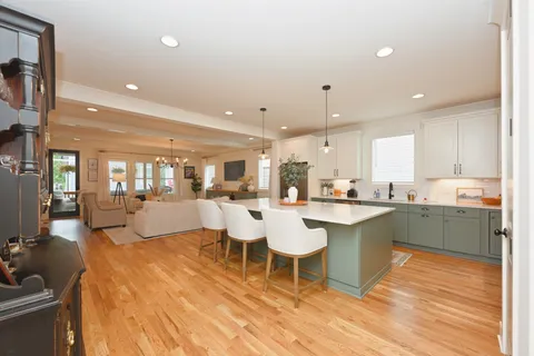 a dining room with furniture a chandelier and wooden floor