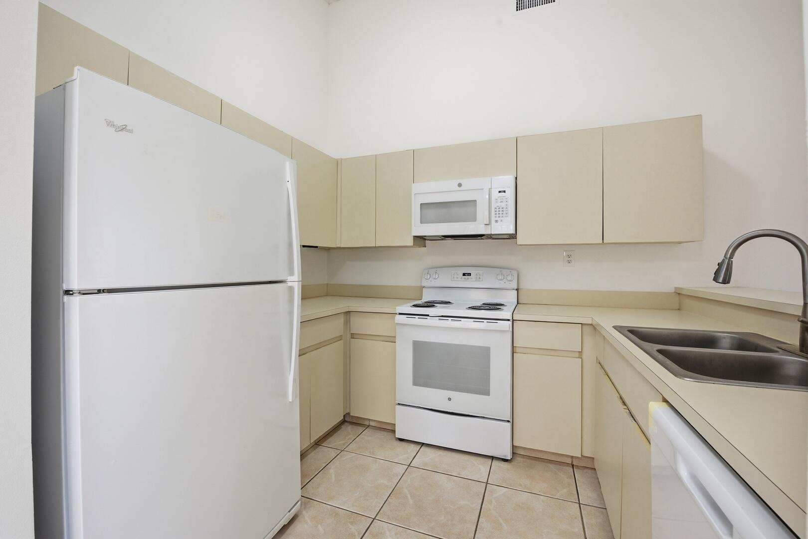 131 Springdale Circle Palm Springs, FL 33461 - Photo 5 of 19 a kitchen with a refrigerator sink and cabinets