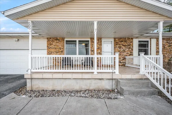 a porch with a bench next to a yard