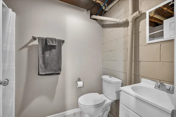 a bathroom with a toilet sink vanity and shower