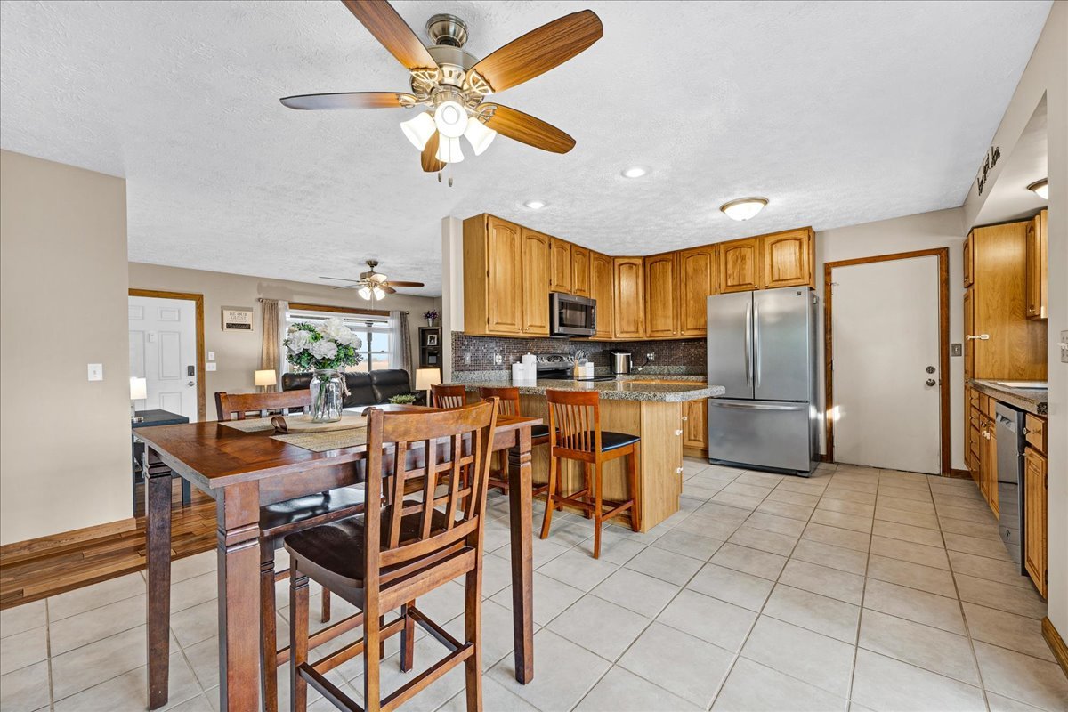 505 West North Street Danvers, IL 61732 - Photo 5 of 45 a kitchen with stainless steel appliances kitchen island granite countertop a refrigerator a stove a sink a dining table and chairs with wooden floor