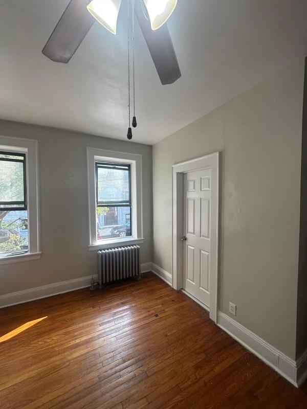 1 Noll Place, Unit 2 Newark, NJ 07106 - Photo 6 of 10 an empty room with wooden floor chandelier fan and windows