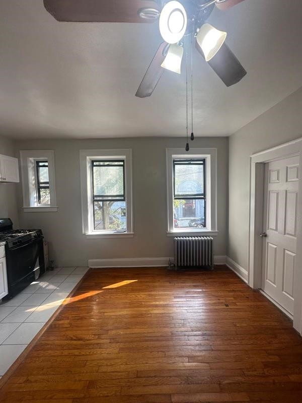 1 Noll Place, Unit 2 Newark, NJ 07106 - Photo 8 of 10 an empty room with wooden floor fan and windows