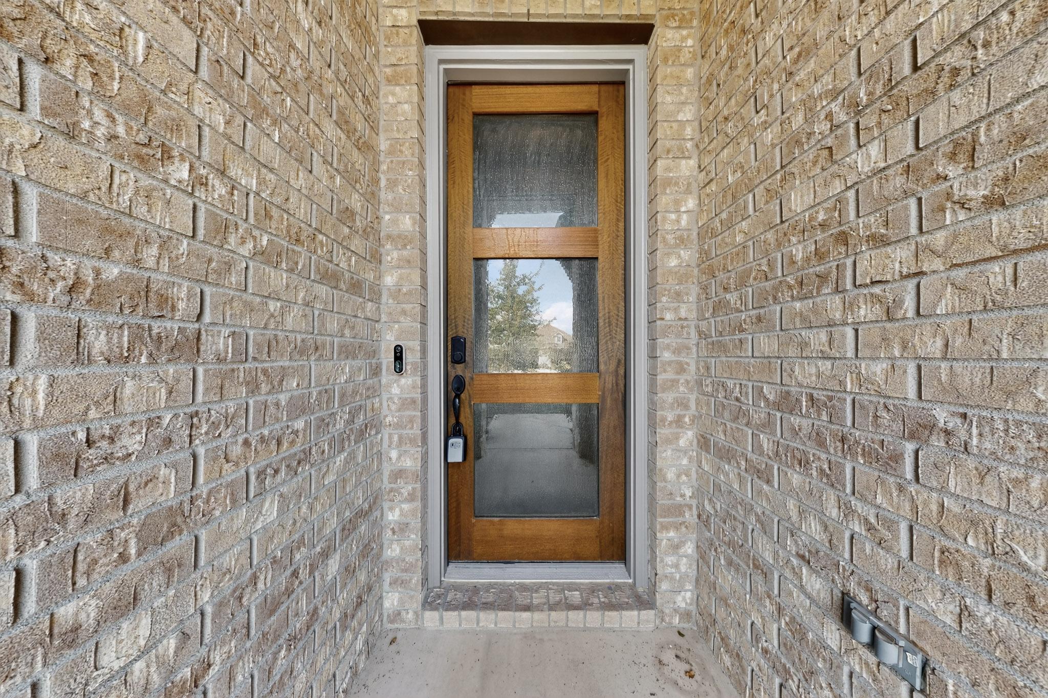 20912 Carries Ranch Road Pflugerville, TX 78660 - Photo 18 of 20 An inviting entryway is framed by classic brickwork and a modern wood door.