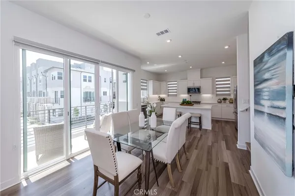 a kitchen with white cabinets and wooden floor