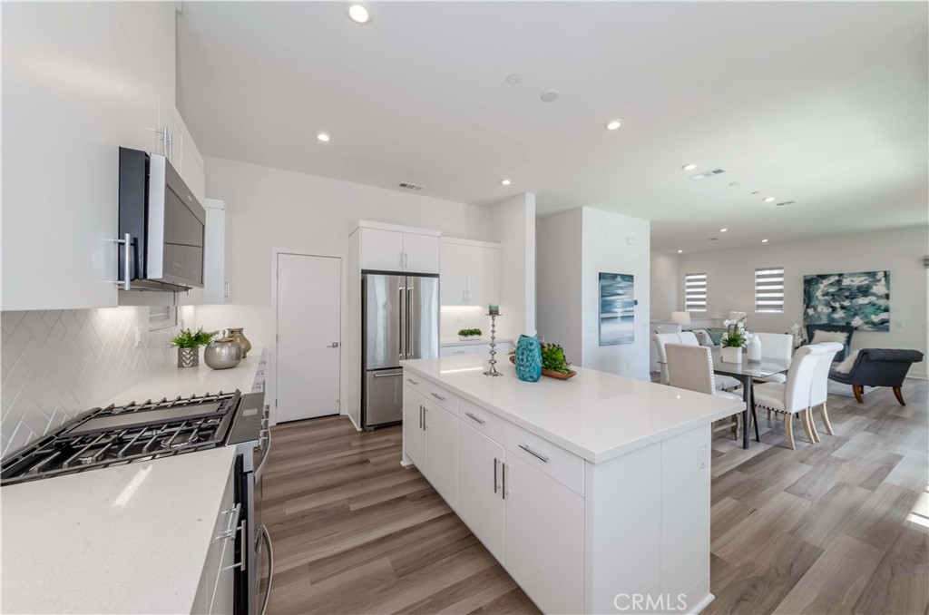 1403 West Bushell Street Anaheim, CA 92805 - Photo 27 of 34 a large white kitchen with stainless steel appliances granite countertop a lot of counter space and wooden floor