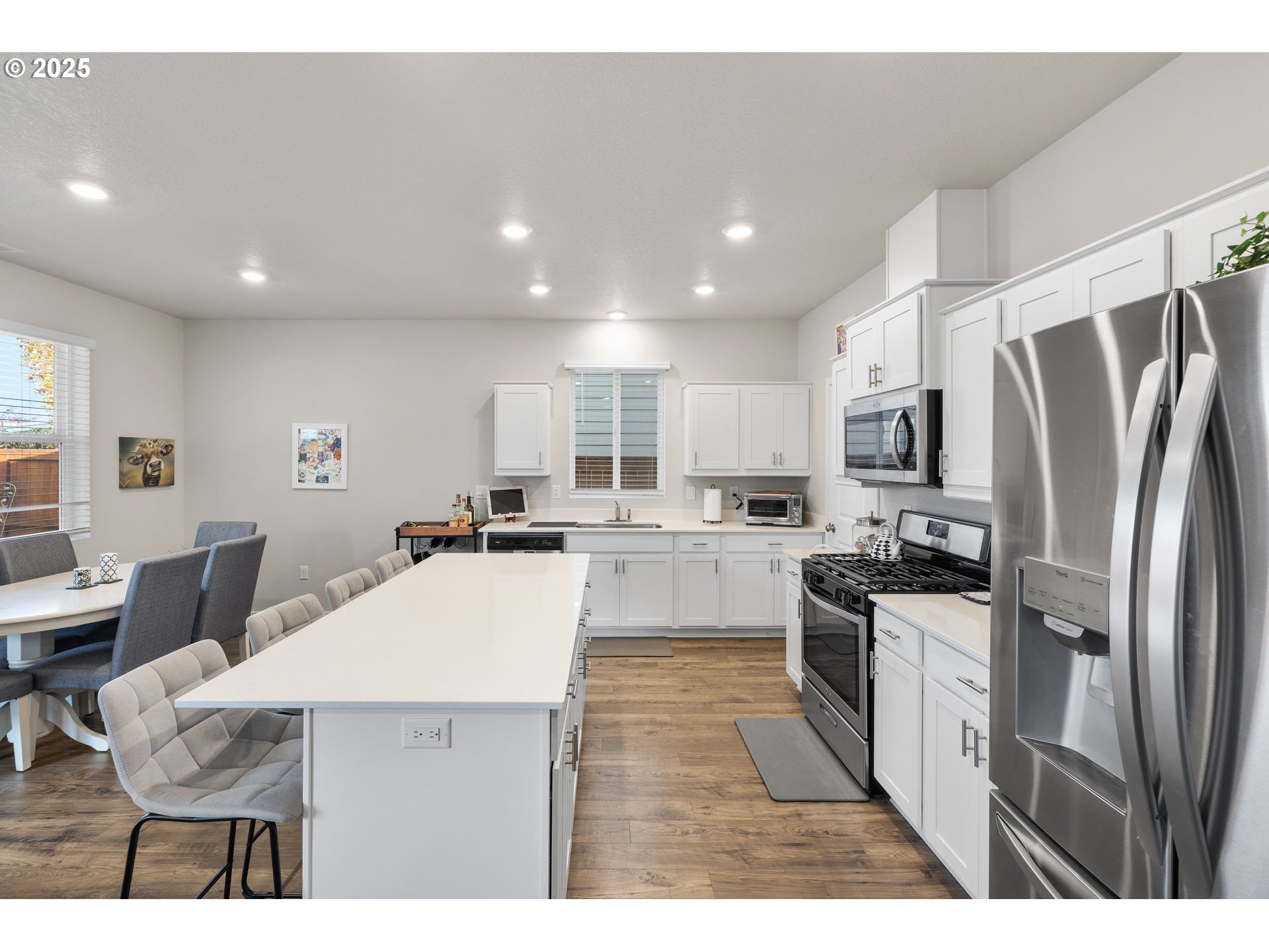 371 Himalaya Street Salem, OR 97301 - Photo 13 of 34 a kitchen with stainless steel appliances kitchen island granite countertop a refrigerator a stove a sink dishwasher and white cabinets with wooden floor