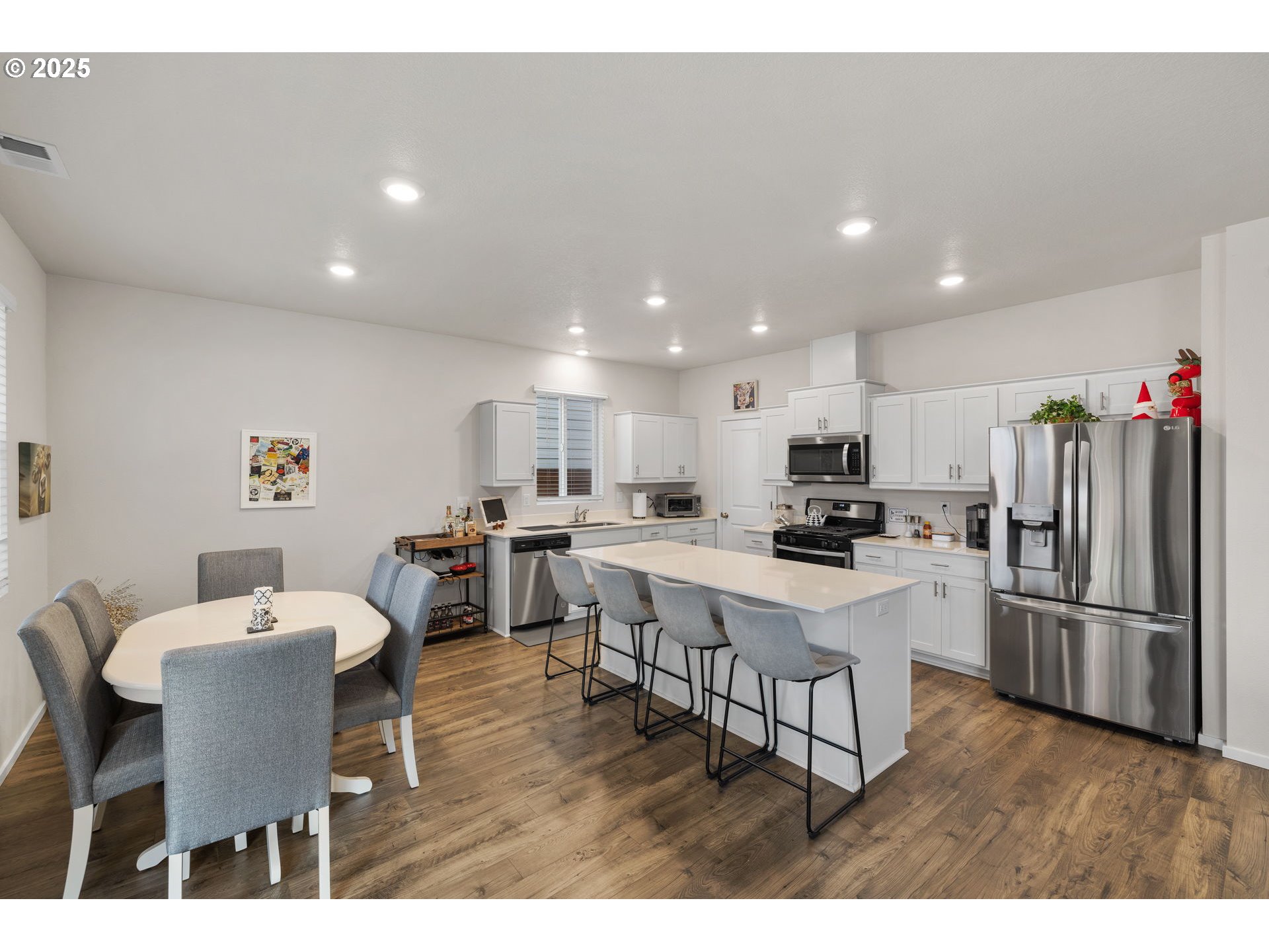 371 Himalaya Street Salem, OR 97301 - Photo 14 of 34 a kitchen with a dining table wooden floor and a refrigerator