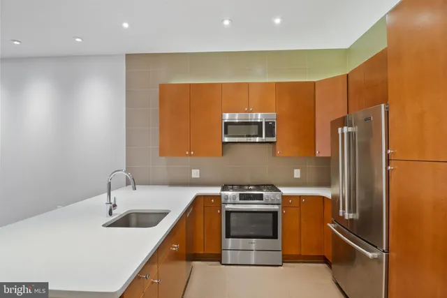 a kitchen with a sink and dishwasher with wooden floor