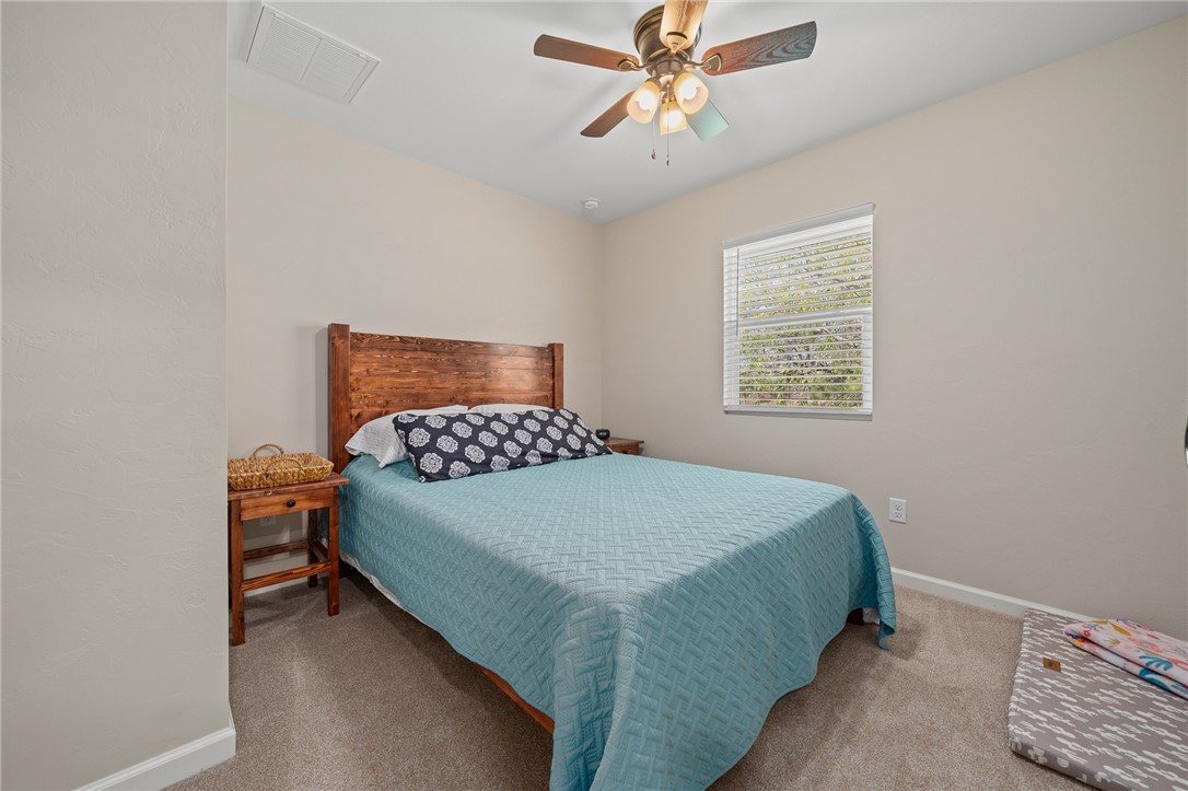 726 3rd Street Bayside, TX 78340 - Photo 16 of 40 a bedroom with a bed and a chandelier