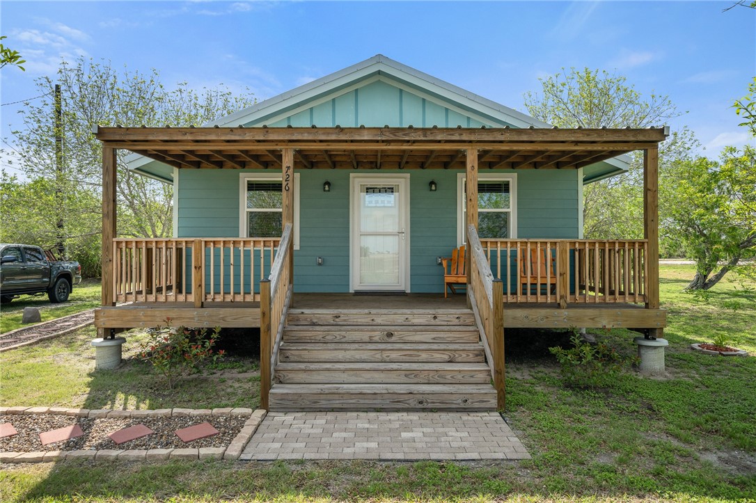 726 3rd Street Bayside, TX 78340 - Photo 2 of 40 a view of a house with small yard plants and large tree