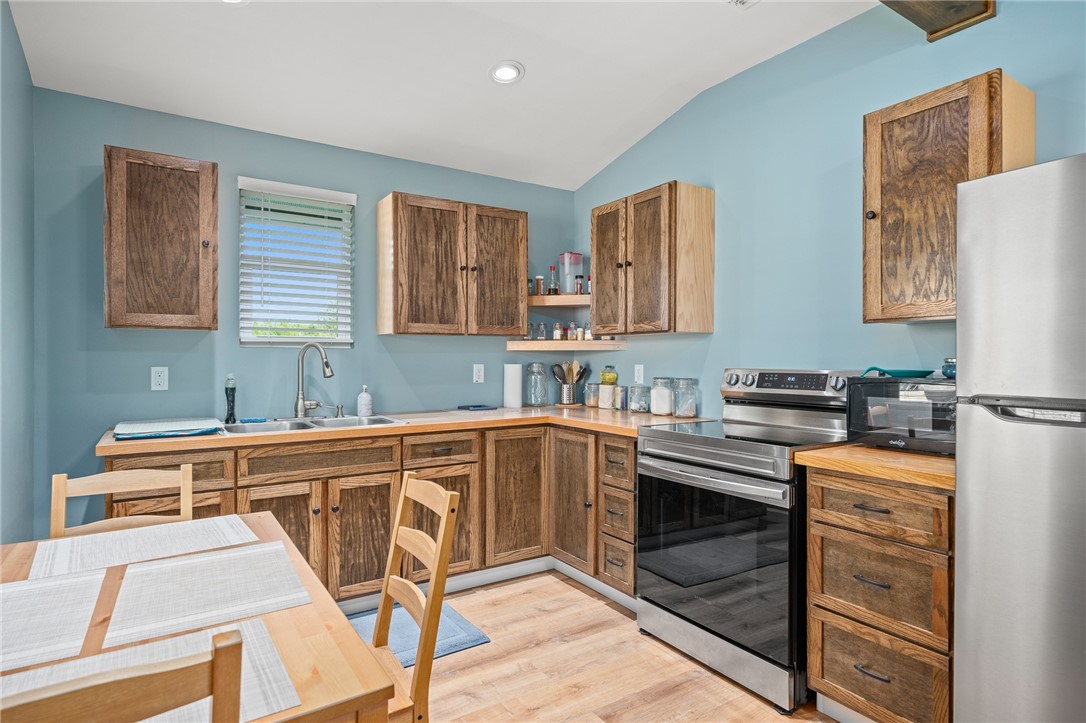726 3rd Street Bayside, TX 78340 - Photo 10 of 40 a kitchen with stainless steel appliances granite countertop a stove a sink dishwasher and a refrigerator