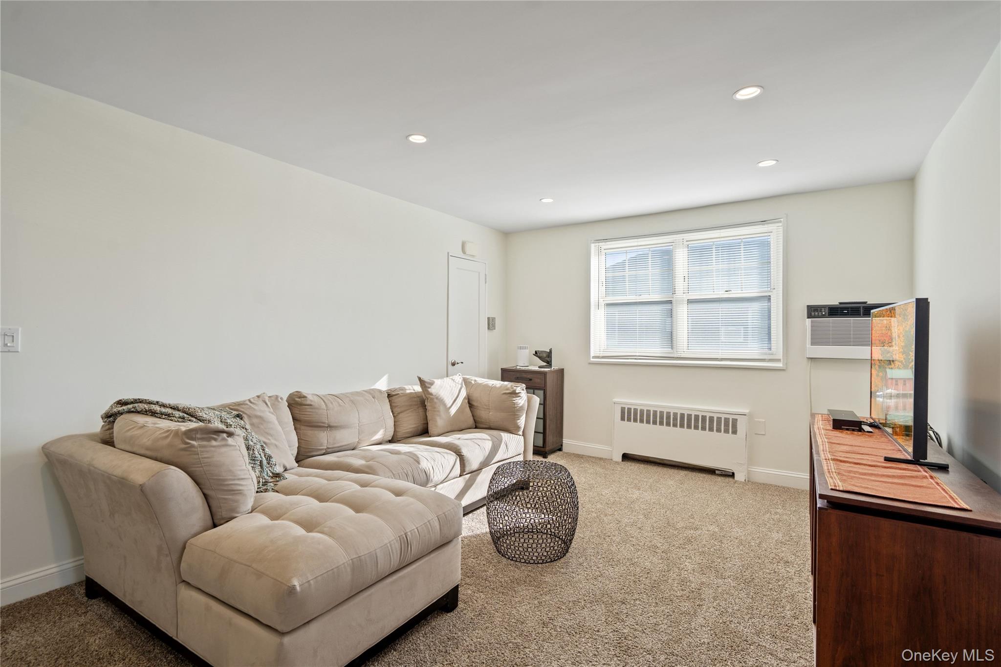 63-09 252nd Street, Unit 41322 Queens, NY 11362 - Photo 15 of 25 a living room with furniture and a window