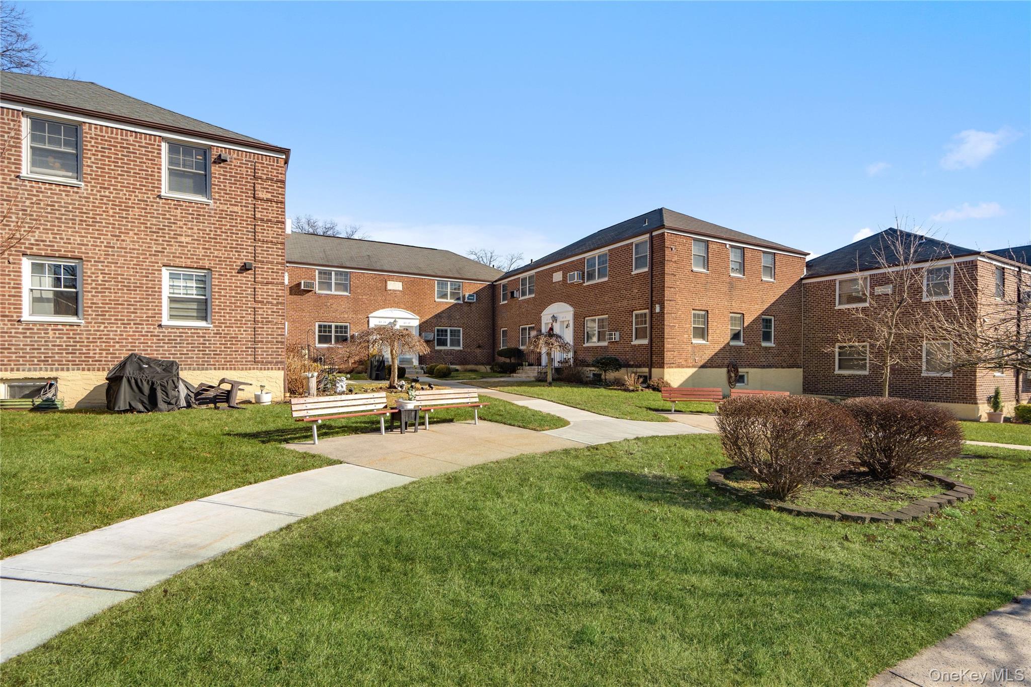 63-09 252nd Street, Unit 41322 Queens, NY 11362 - Photo 24 of 25 a front view of a house with a yard