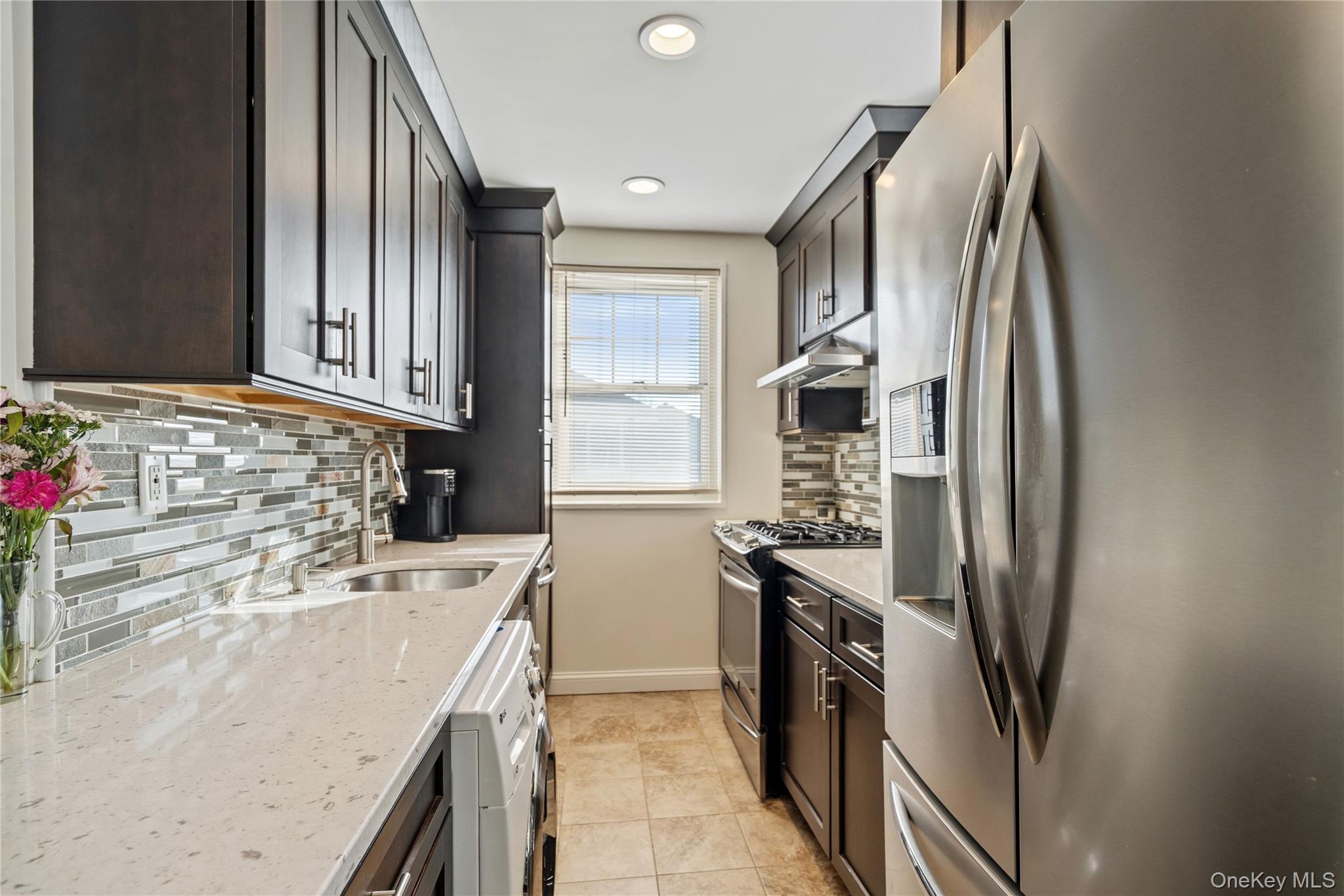 63-09 252nd Street, Unit 41322 Queens, NY 11362 - Photo 6 of 25 a kitchen with stainless steel appliances granite countertop a sink stove and refrigerator