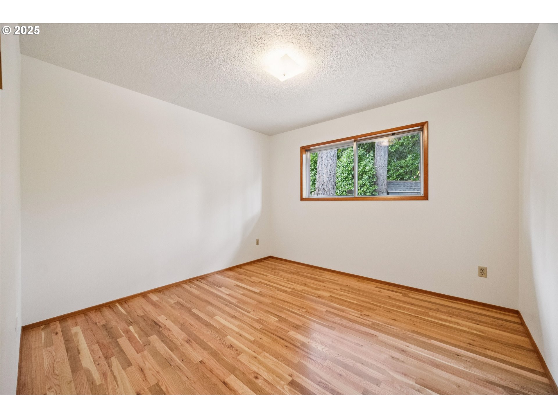 121 Southeast 166th Avenue Portland, OR 97233 - Photo 23 of 27 a view of an empty room with wooden floor