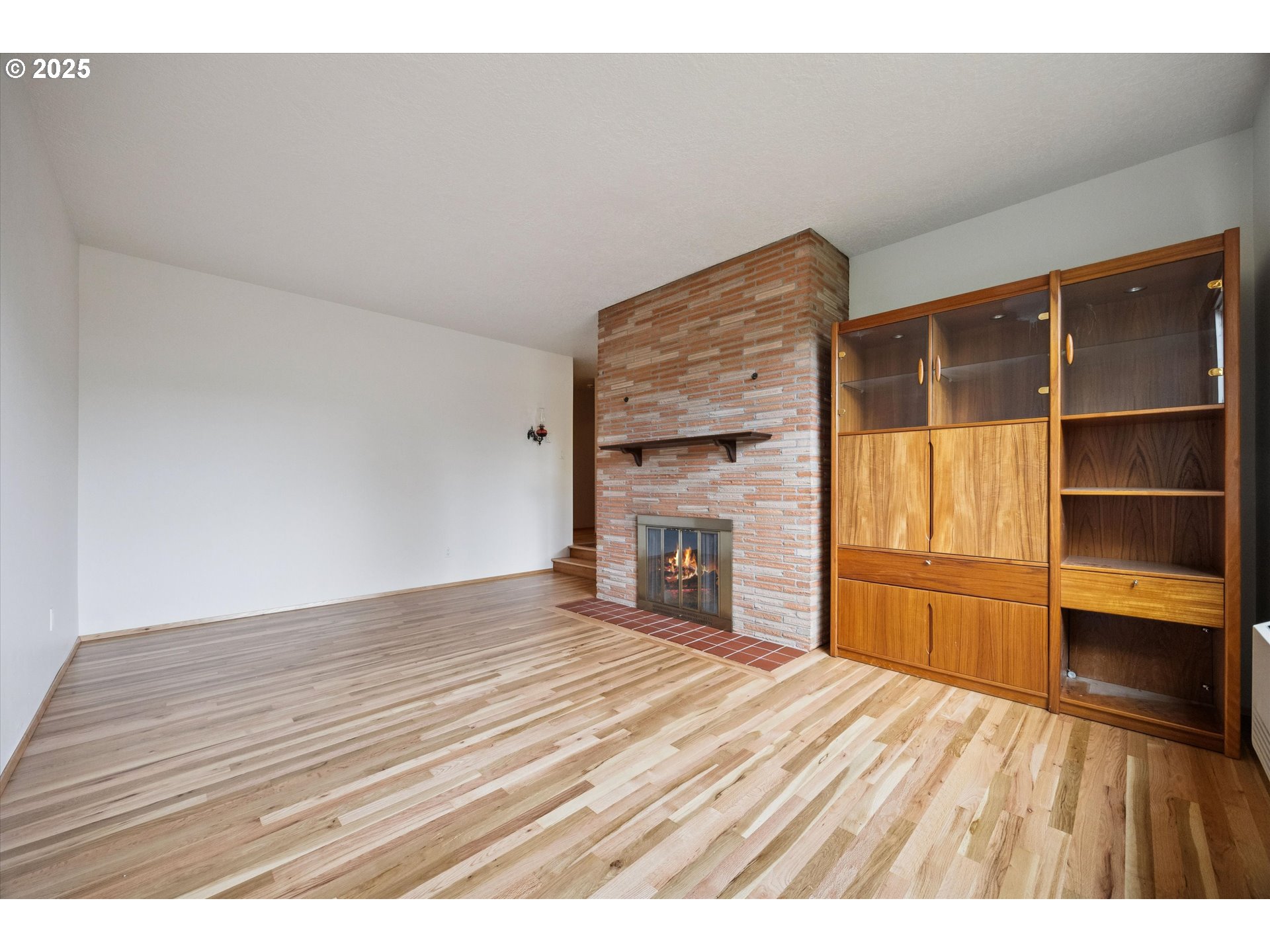 121 Southeast 166th Avenue Portland, OR 97233 - Photo 7 of 27 a view of empty room with a fireplace and wooden floor