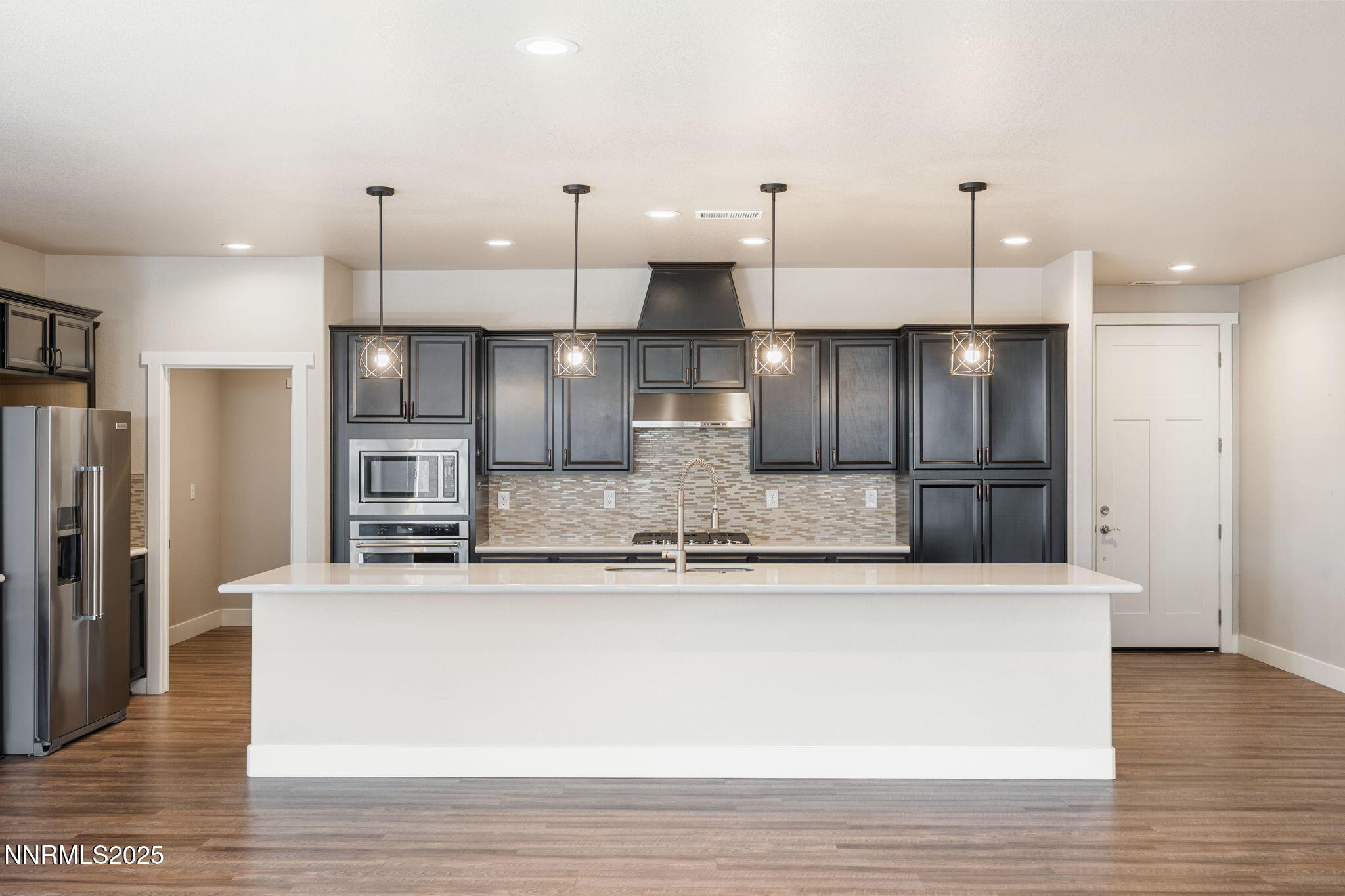774 East Cottage Loop Gardnerville, NV 89460 - Photo 13 of 31 a large kitchen with stainless steel appliances kitchen island a large counter top and a refrigerator