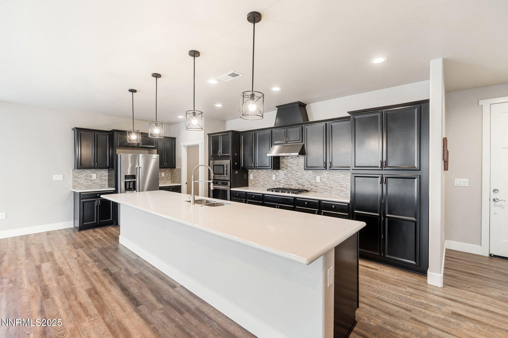 774 East Cottage Loop Gardnerville, NV 89460 - Photo 15 of 31 a large kitchen with kitchen island a large counter top space a sink stainless steel appliances and cabinets