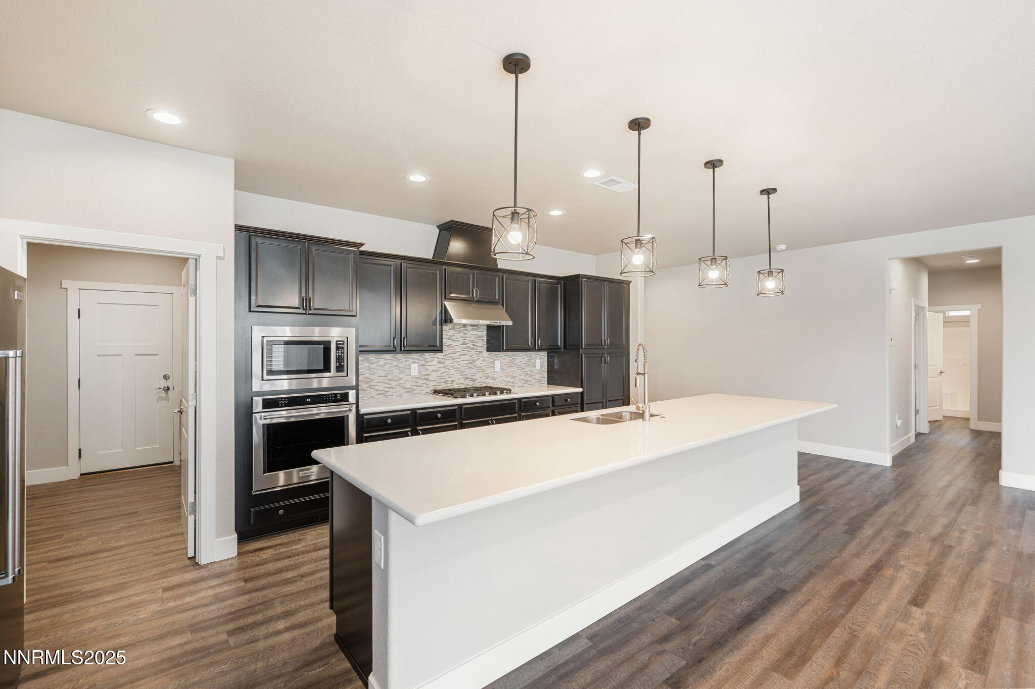 774 East Cottage Loop Gardnerville, NV 89460 - Photo 18 of 31 a large kitchen with kitchen island a stove a sink a refrigerator and a wooden floor