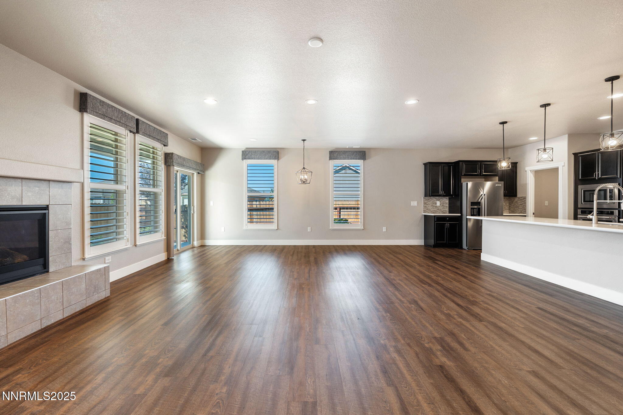 774 East Cottage Loop Gardnerville, NV 89460 - Photo 8 of 31 an empty room with wooden floor and a kitchen