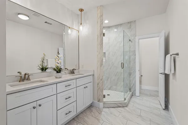 a bathroom with a double vanity sink toilet and shower