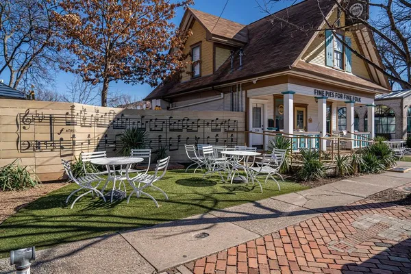 a front view of a house with garden and sitting area