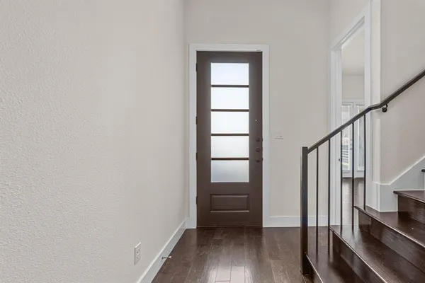 a view of hallway with stairs and wooden floor