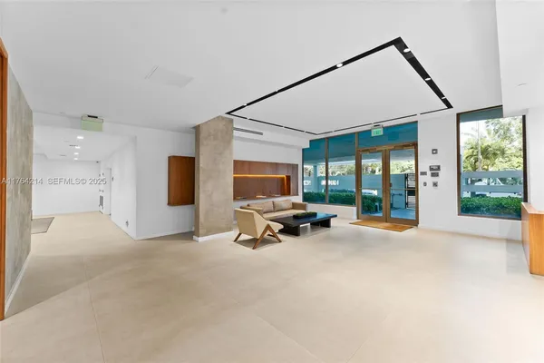 a view of a livingroom with furniture and floor to ceiling window