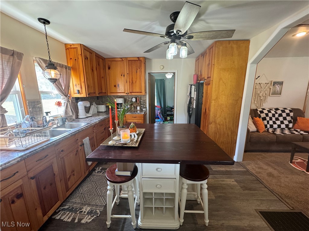 1480 Jerrys Run Road Belleville, WV 26133 - Photo 22 of 48 Kitchen with black refrigerator, decorative light fixtures, ceiling fan, decorative backsplash, and dark colored carpet