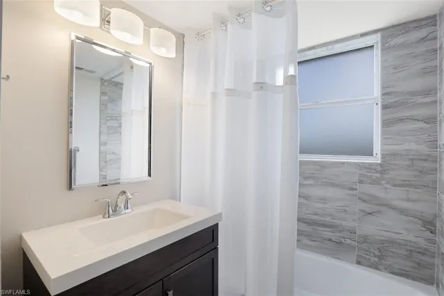 a bathroom with a sink a mirror and a shower