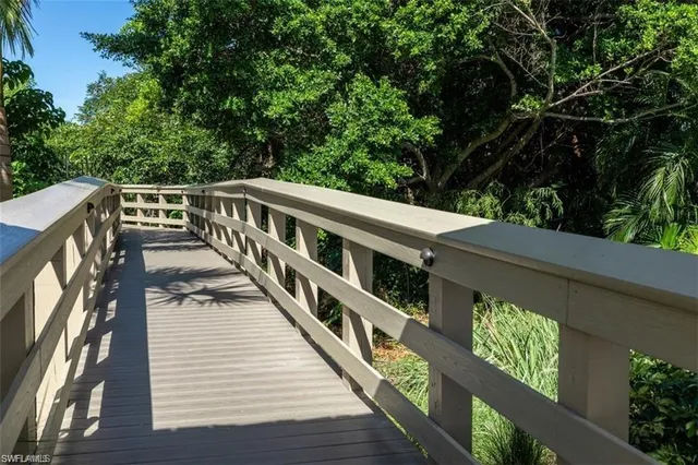 a balcony with wooden floor and trees in the background