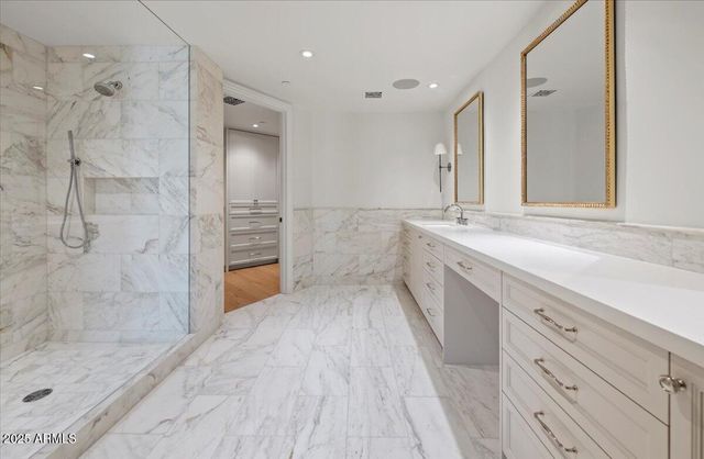 a bathroom with a granite countertop sink mirror and shower