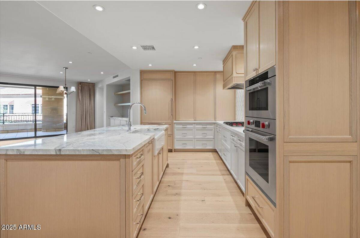 7181 East Camelback Road, Unit 301 Scottsdale, AZ 85251 - Photo 7 of 22 a large kitchen with stainless steel appliances kitchen island granite countertop a large counter top and a stove
