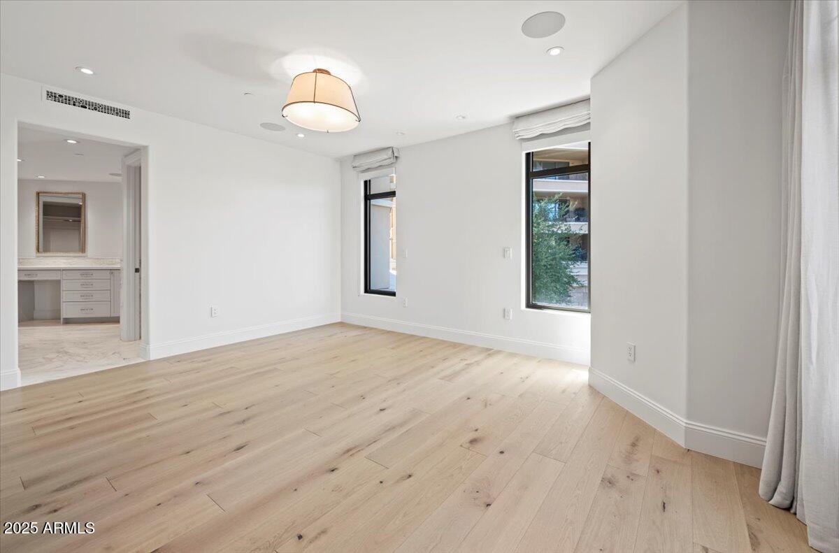 7181 East Camelback Road, Unit 301 Scottsdale, AZ 85251 - Photo 10 of 22 an empty room with wooden floor and windows