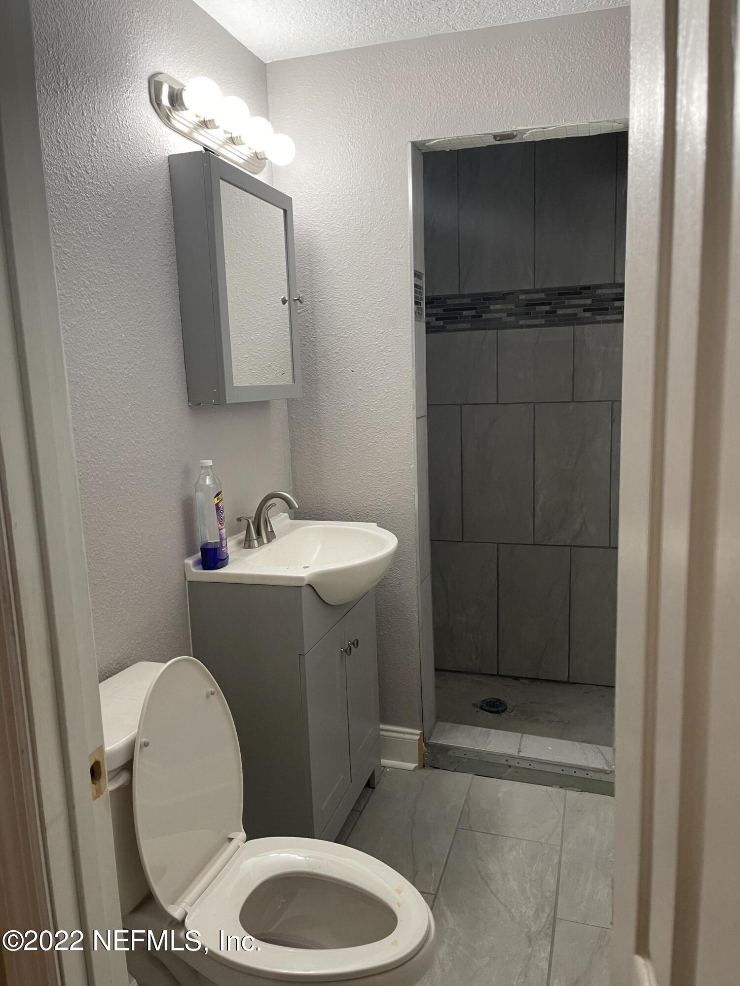 3111 Ray Road Jacksonville, FL 32209 - Photo 18 of 19 a bathroom with a toilet a sink a vanity and mirror