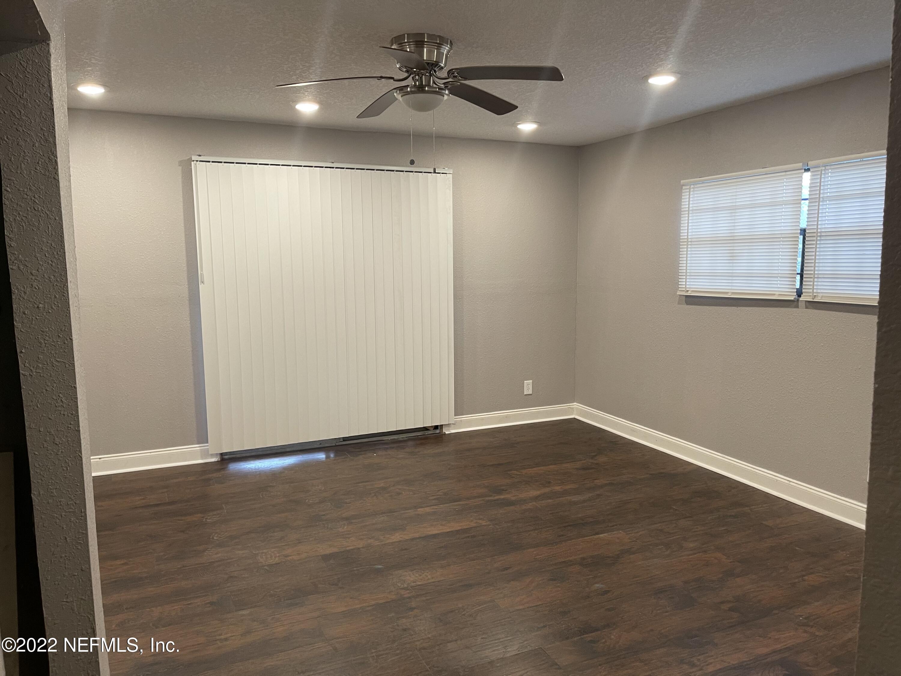 3111 Ray Road Jacksonville, FL 32209 - Photo 6 of 19 an empty room with wooden floor fan and windows