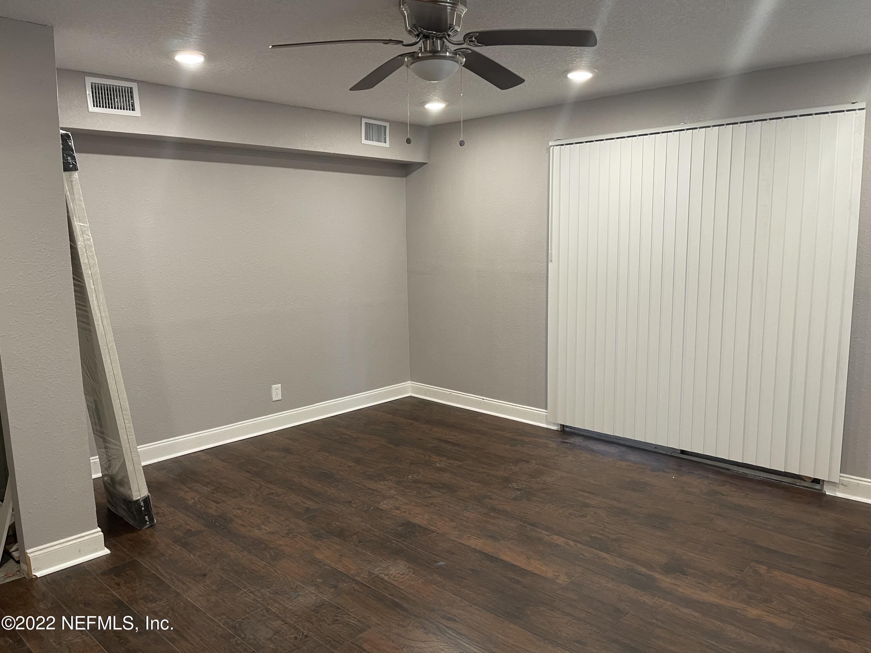 3111 Ray Road Jacksonville, FL 32209 - Photo 7 of 19 an empty room with wooden floor and fan