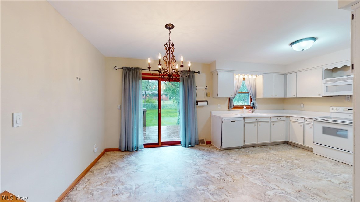 6400 Brookside Road Independence, OH 44131 - Photo 20 of 47 Kitchen with light tile floors, white cabinets, sink, white appliances, and pendant lighting